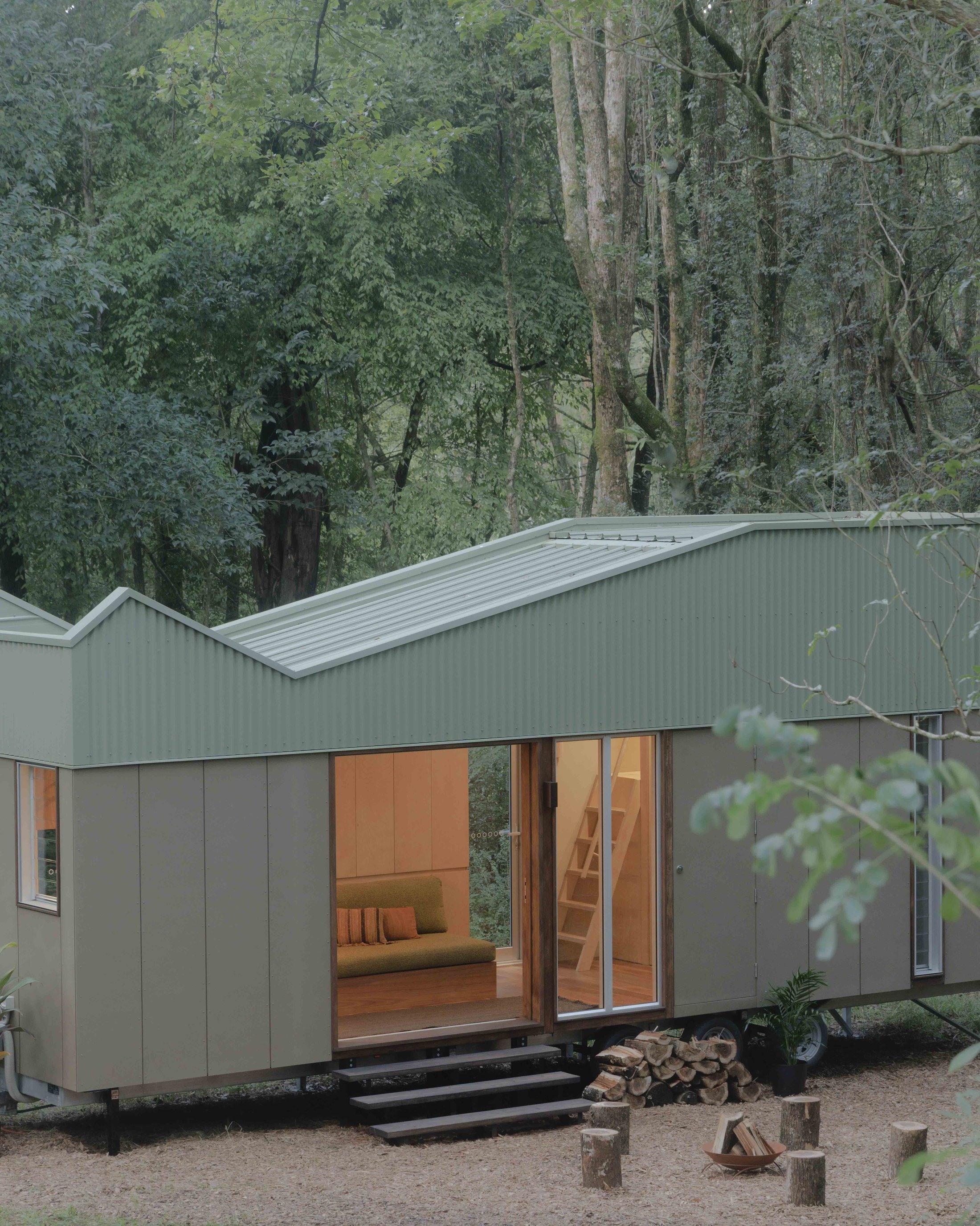 Exterior view at dusk, sliding door open onto timber deck